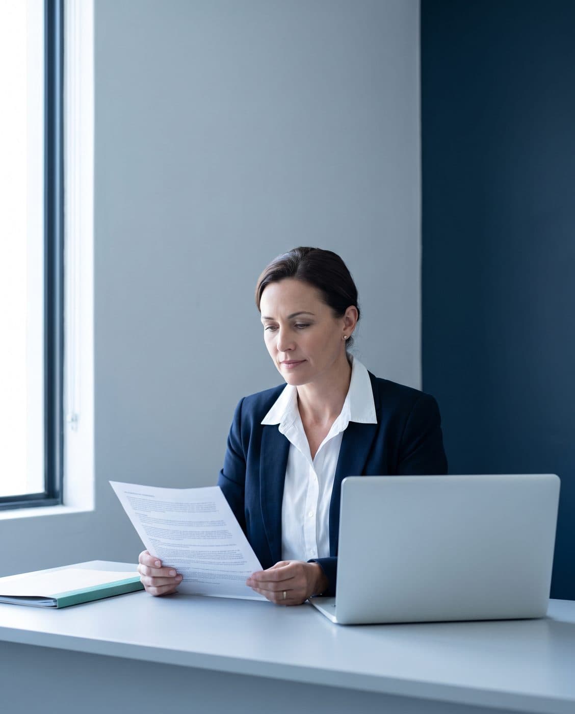 A practice manager reviewing medical scheme correspondence at a desk